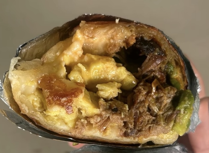 The Cafe Racer burrito cut in half, showing pulled pork and avocado