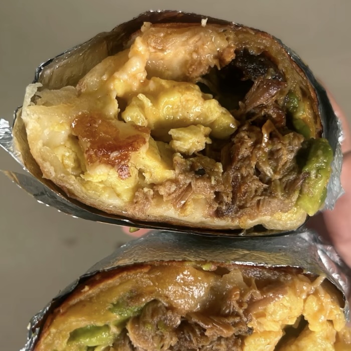 The Cafe Racer burrito cut in half, showing pulled pork and avocado